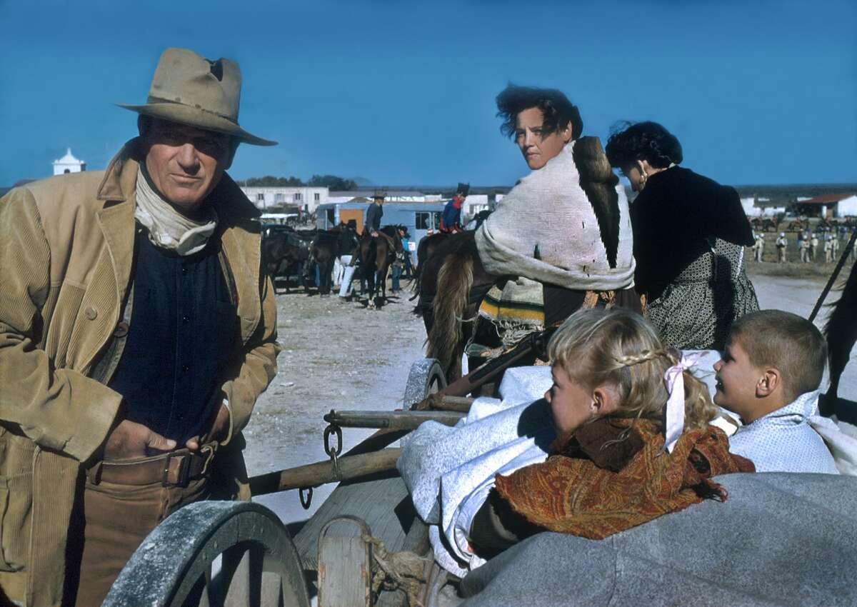 In costume (as Colonel Davy Crockett), American actor John Wayne (1907 - 1979) (left) directs unidentified cast members in a scene from their film 'The Alamo', Brackettville, Texas, 1960. (Photo by Tom Nebbia/Corbis via Getty Images)