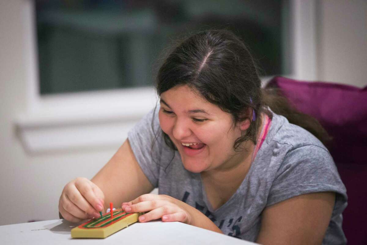 Alexia Stamatis, 13, becomes excited as she starts winning a board game against her mother Karen Aramburu after dinner at their home in Katy, Wednesday, Dec. 7, 2016. The board game requires counting which enforces skills Stamatis learns in her special education mathematics class at West Memorial Junior High School. ( Marie D. De Jesus / Houston Chronicle )