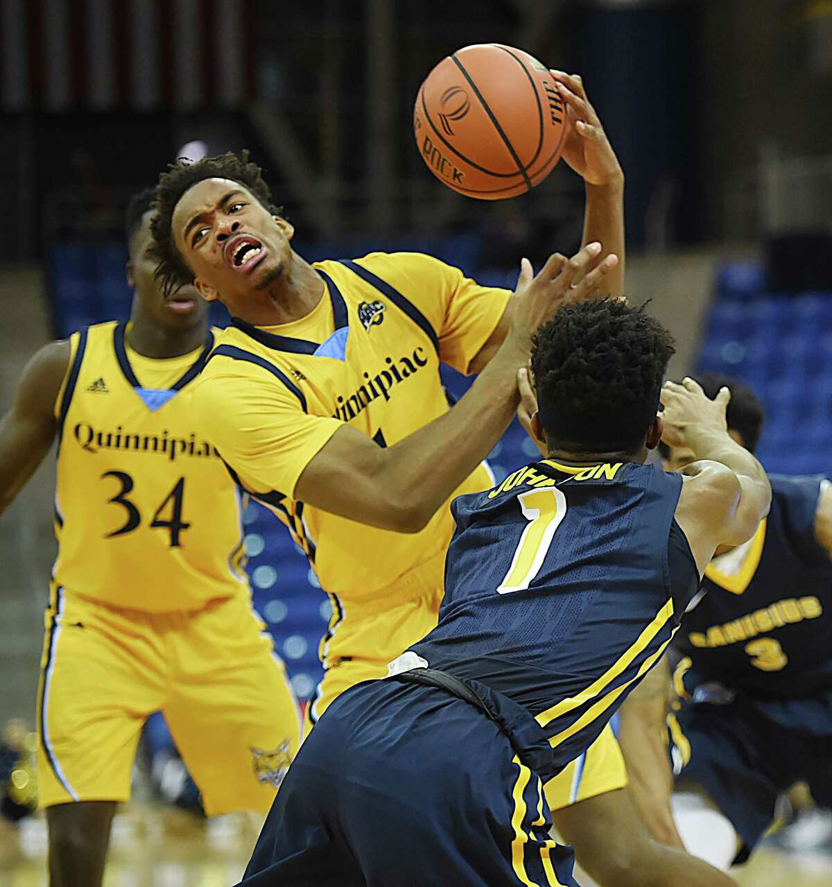 Quinnipiac senior guard Cameron Young is fouled by Canisius sophomore guard Malik Johnson for a loose ball, Friday, Jan. 5, 2018, at the TD Bank Sports Center in Hamden. Canisius won, 82-74.