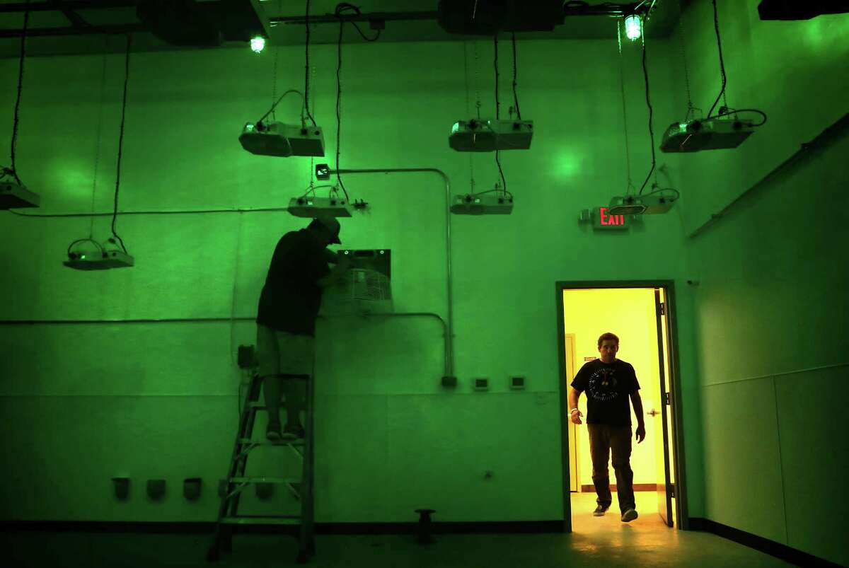 Morris Denton, CEO of Compassionate Cultivation, walks into a vegetative room lit with green lights which simulates night time for marijuana plants that will be grown in the room, where a climate control person is working. Denton is one of only three entities expected to soon get a license to grow medical cannabis, in his soon to open location in South Austin.