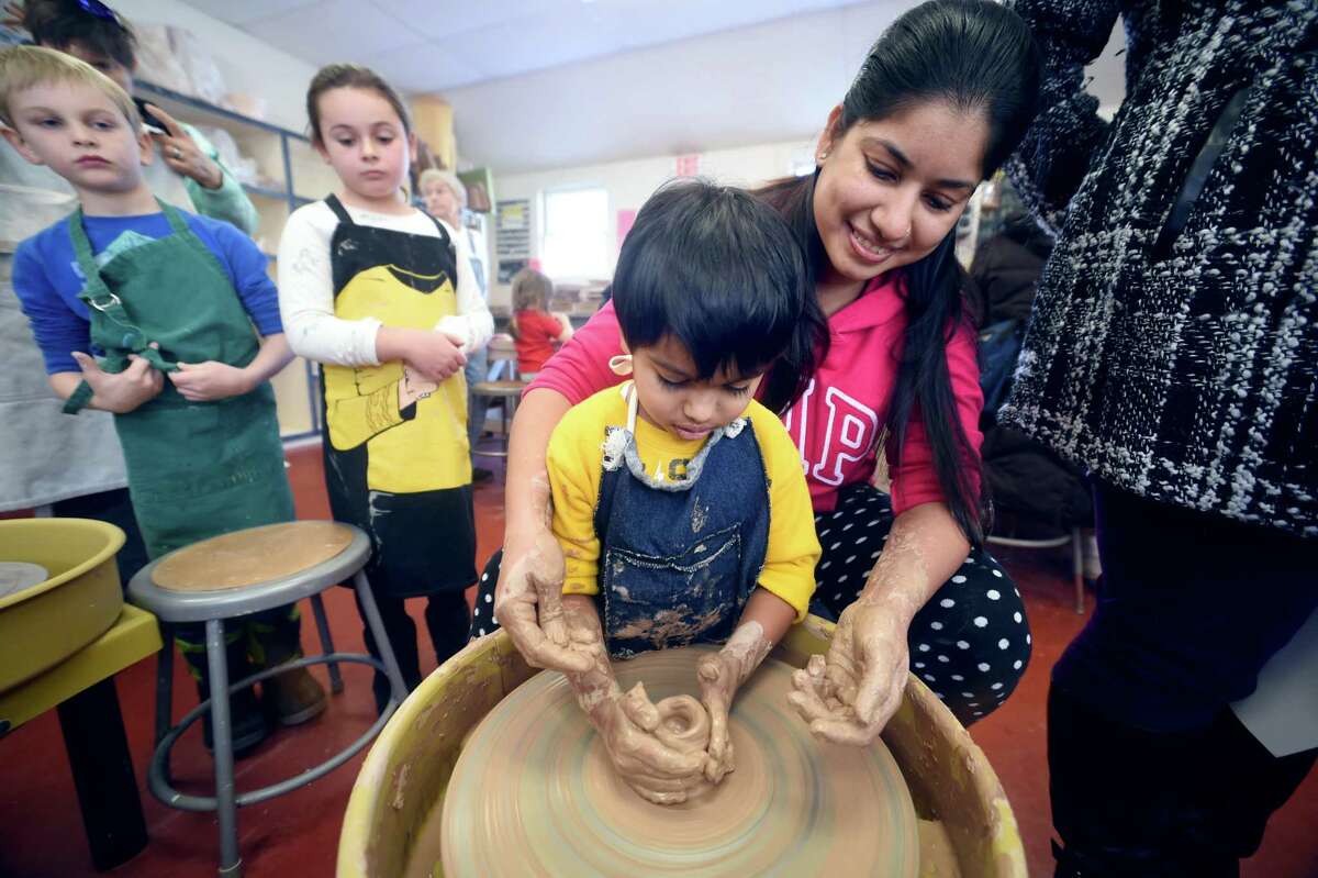 Shaurya Bajaj, 4, of Groton, takes a turn on the potter's wheel with his mother, Urmila, during the 6th annual Open Arts Day at the Guilford Arts Center on January 7, 2018.