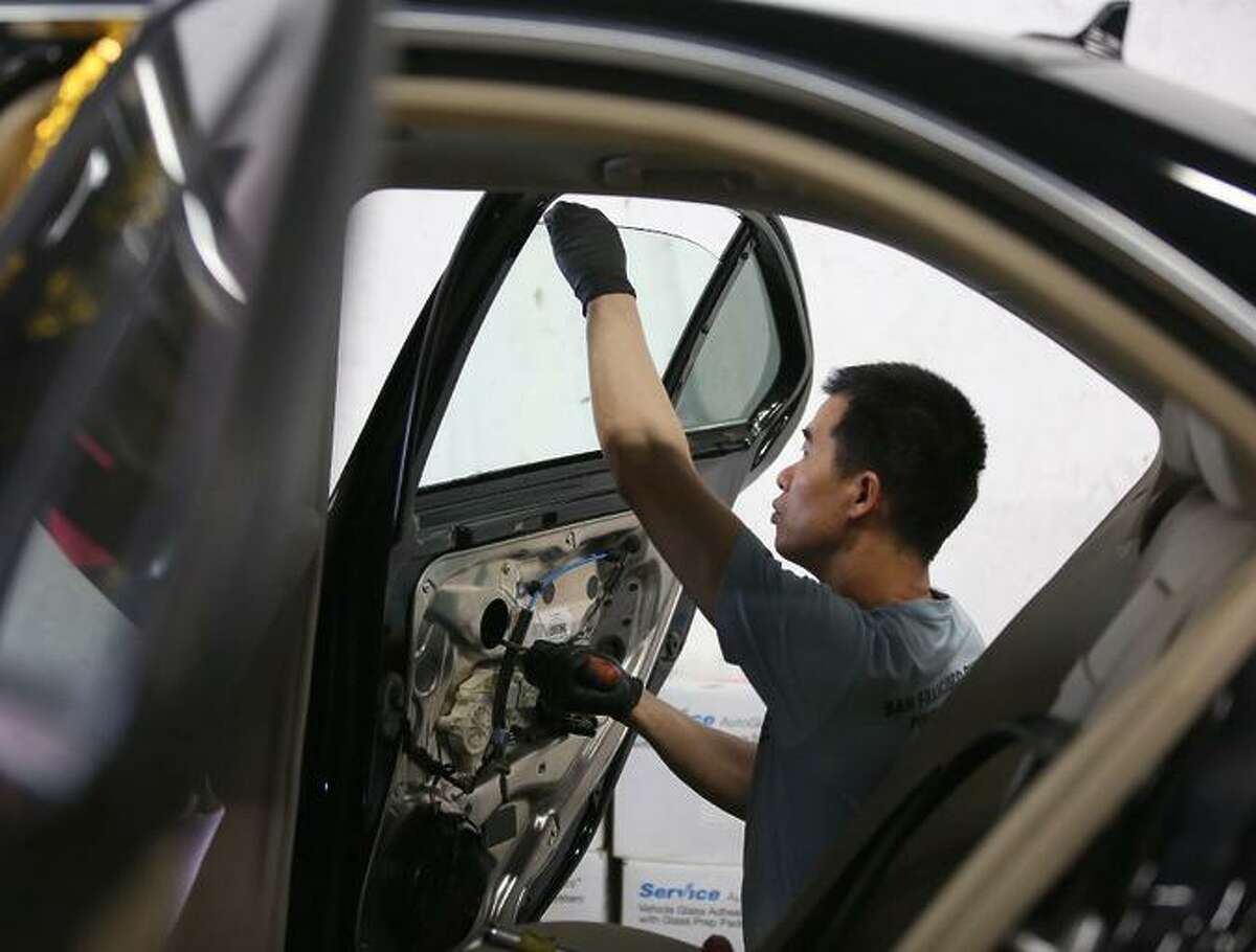 At TLC Auto Glass in San Francisco, Jimmy Lee replaces a car’s window in August after a break-in.