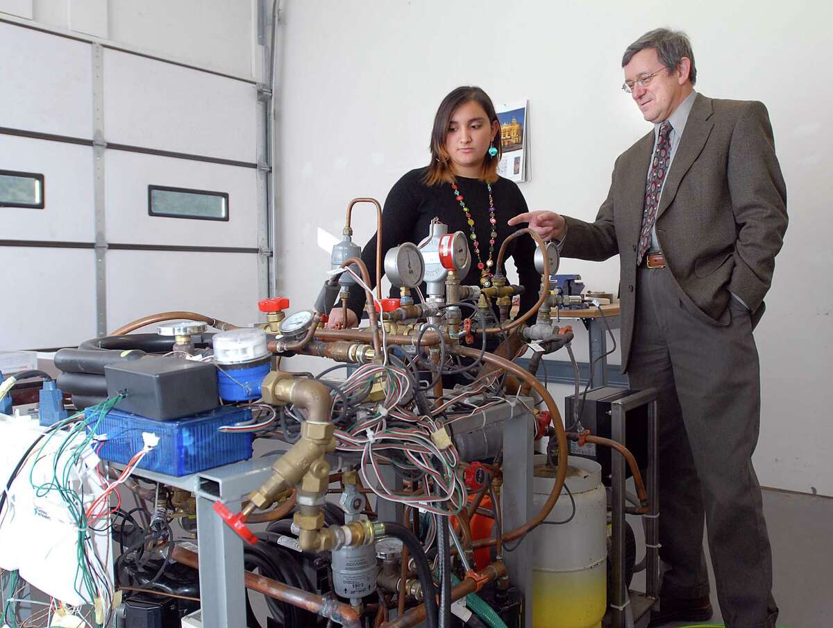 Cas100106 01/06/10 Madison--Mark Bergander, President of Magnetic Development Inc. works with new research assistant Emily Fisler with the company's research test equipment. . Photos -Peter Casolino/New Haven Register *