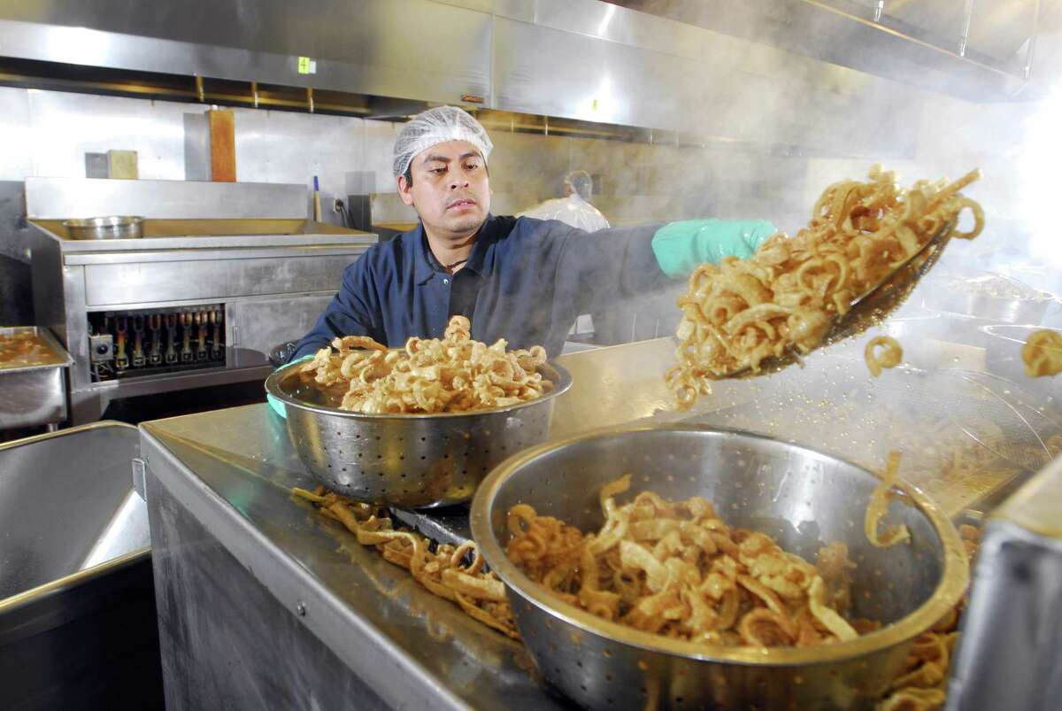 Photography by PETER HVIZDAK ph1199 #7144 Hamden, Connecticut - December 17, 2009: Gerardo DeLeon, separates fried pork skins as he works on the deep frying line at The International Group, Inc. company in Hamden. Known for its' fried pork skins, especially Howard's Fried Pork Skins, the company makes ethnic snack foods and other food products as well as being a major ethnic food importer.