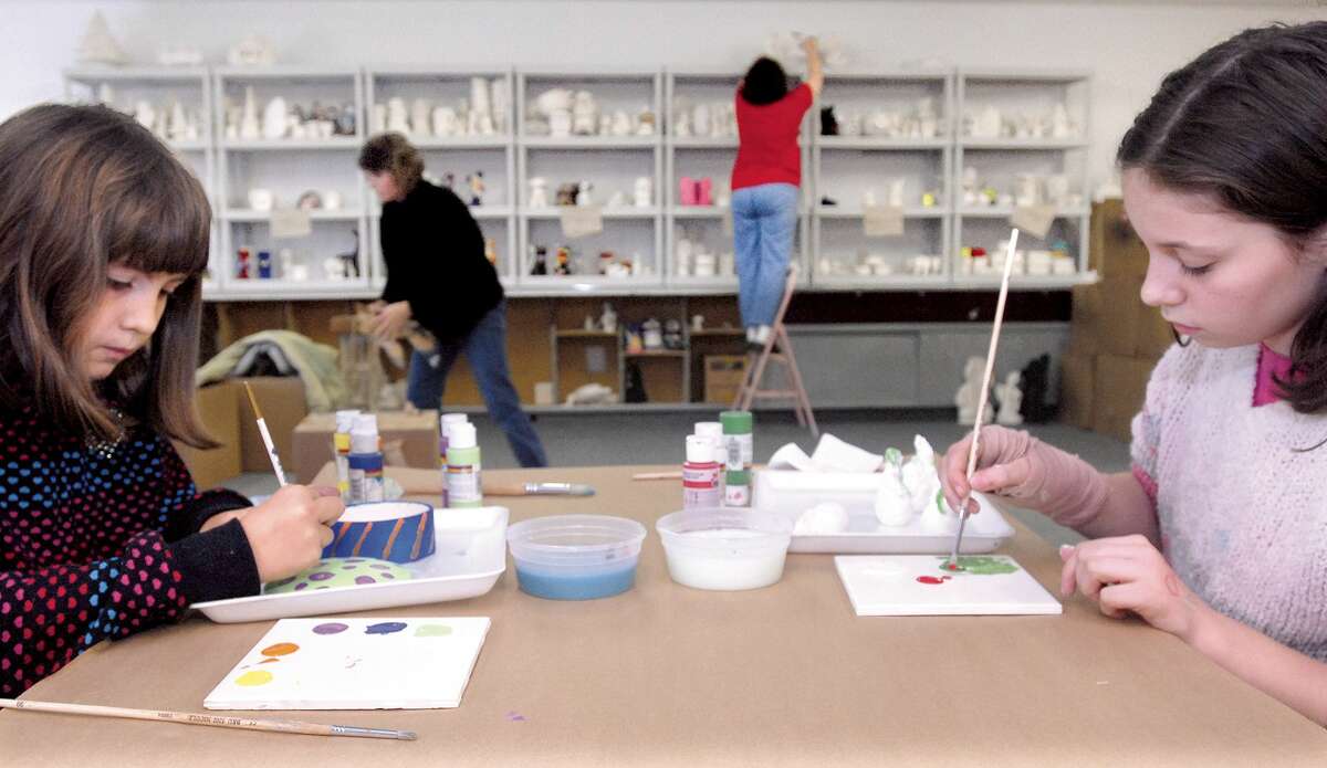 Brad Horrigan | New Haven Register. BH0014. Orange, Connecticut - 12.22.07: Sydney Young, 9, of Milford, and Bridget D'Onofrio, 11, of North Haven, paint selected ceramic pieces at Ceramic Fun Time in Orange on Saturday. In the back, Lisa Young and Noreen D'Onofrio help place various ceramic pieces on proper shelves in an effort to fully prepare the shop after last fall's fire and restoration.