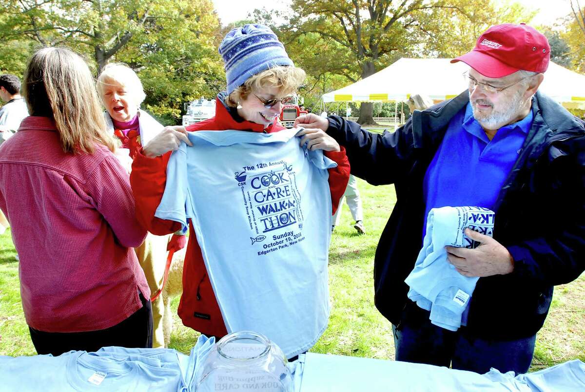 cit-walkathon-ag-10/19/08 Ann Yost (center) and her husband, Arthur (right), get their Cook and Care Walk-A-Thon t-shirts at Edgerton Park in New Haven on 10/19/2008. Photo by Arnold Gold AG0282C