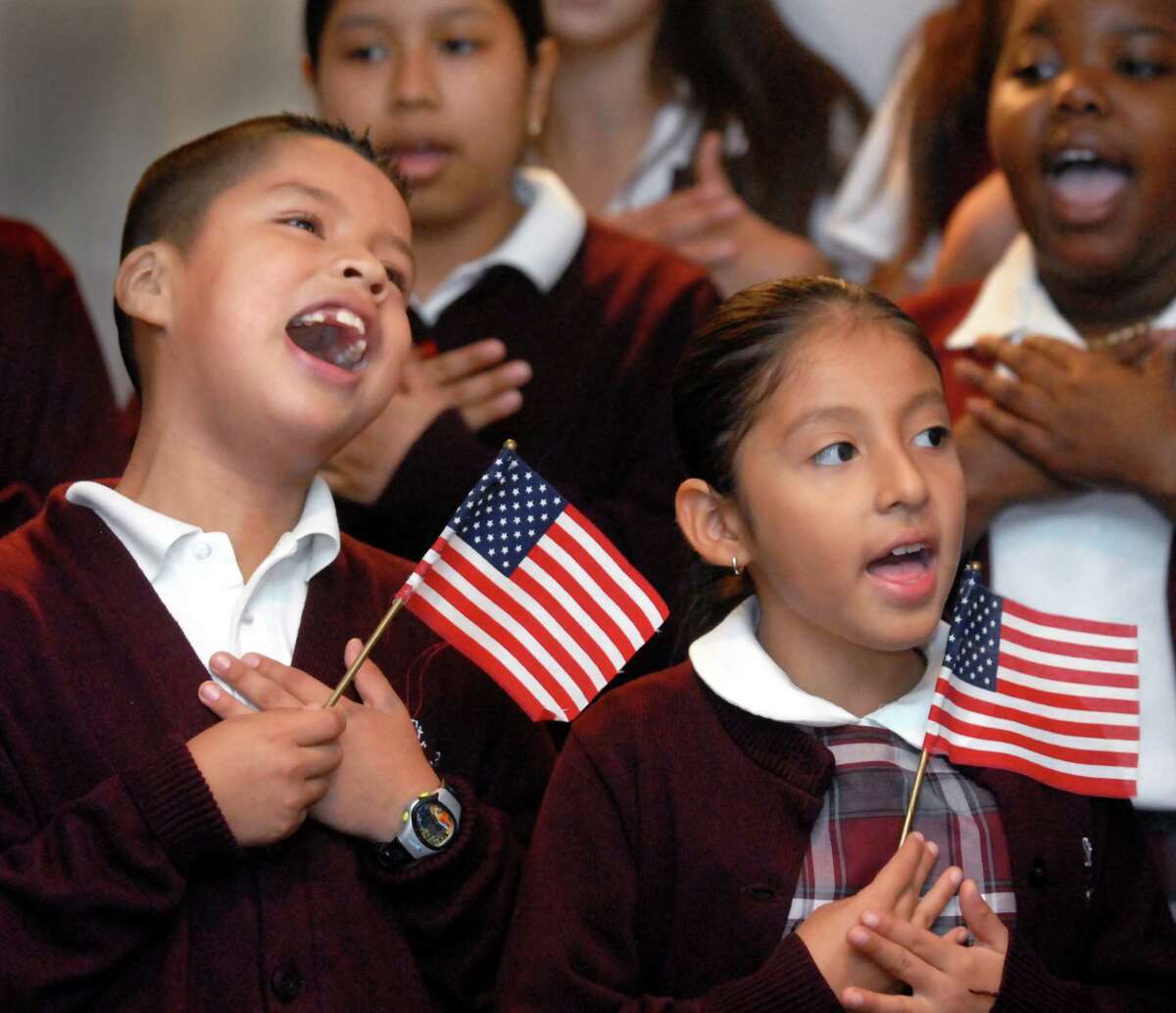 (ms100407)-William Aleman and Brithney Abad sing "God Bless America" with the school choir, at the Archbishop's 1st Annual Columbus Day Breakfast. They are both in the 3rd grade at St. Rose of Lima School in New Haven. Melanie Stengel/Register