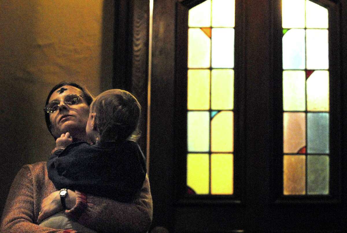 Brad Horrigan | New Haven Register. BH0045. New Haven, Connecticut - 02.06.08: After receiving ashes, Elisabeth Dobbins holds her daughter, Anna Dobbins, 23 months, at St. Mary's Church in New Haven on Wednesday afternoon. Ash Wednesday marks the beginning of the 40 days of Lent.