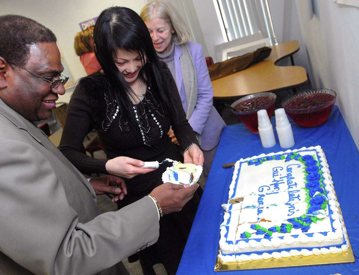 Brad Horrigan | New Haven Register. BH0066. New Haven, Connecticut - 03.05.08: Gui Hong Geremia cuts a piece of her cake for New Haven Superintendent of Schools Reginald Mayo at the Adult Education building on Wednesday. Hong Geremia is the recipient of the Connecticut Association of Adult and Continuing Education 2008 Adult Learner Award.
