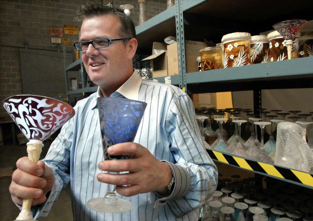 11/11/09 2 CLS ML0591G Shane Keegan, owner of Creative Logistic Solutions in West Haven with some of the product his company is working with, glasses on which designs are sandblasted. Photo by Mara Lavitt