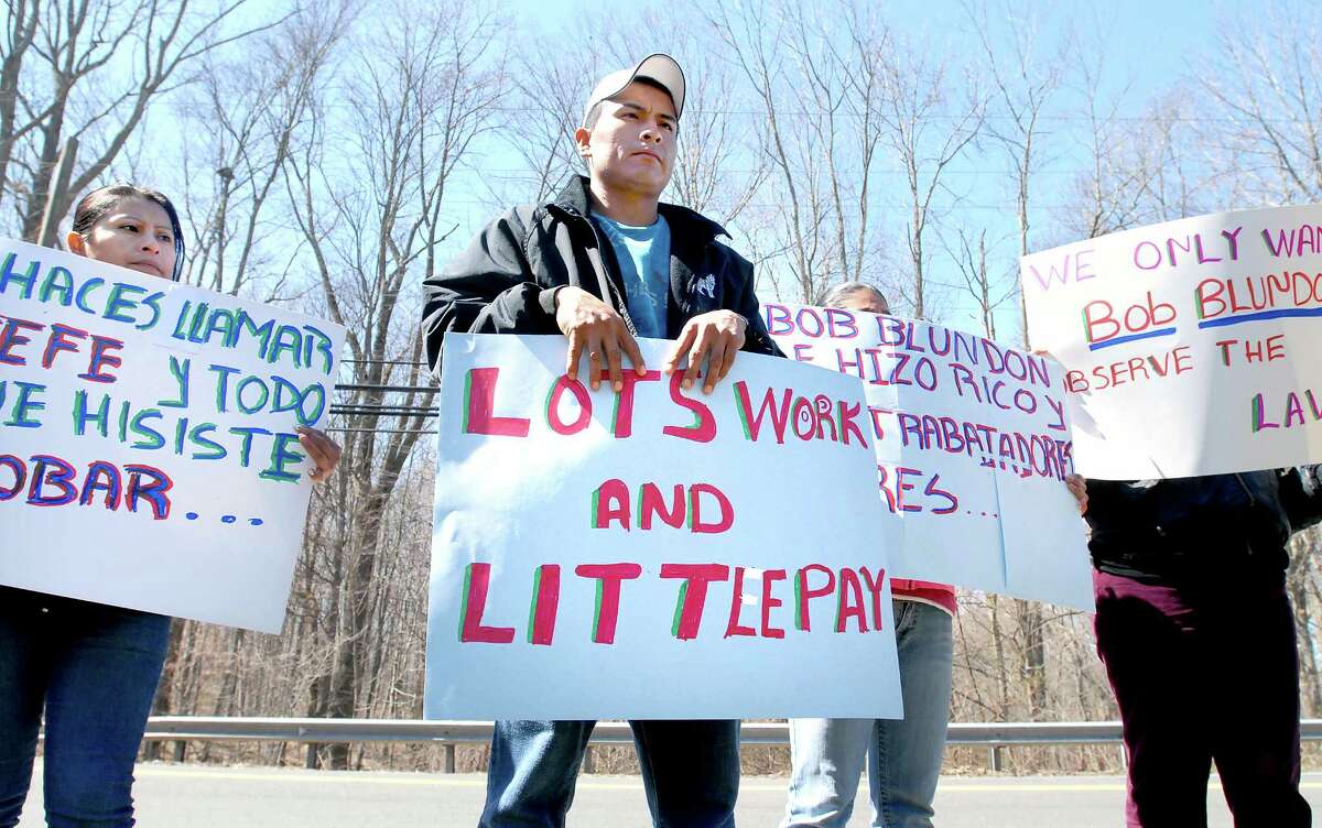 mad-wage protest-ag-3/31/09 Elizabeth Garcia (left) and Carlos Perez (center) of New Haven were among those protesting in front of Madison Earth Care Services in Madison on 3/31/2009 over unpaid overtime wages. Photo by Arnold Gold AG0305B