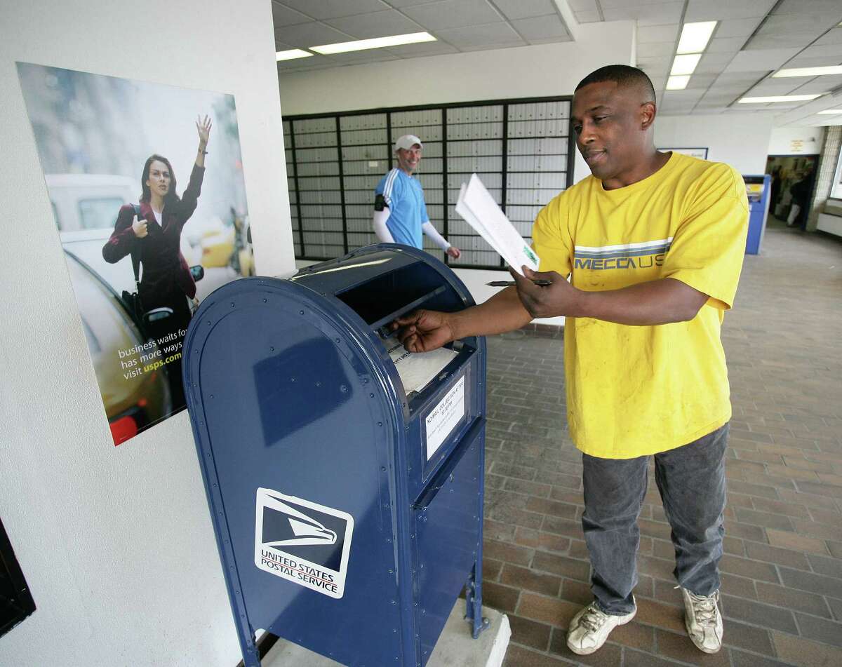 Peter Casolino Cas090415 4/15/09 New Haven--Vernon Williams of West Haven sends out his taxes in a special mailbox (for mail addressed to the IRS) set up in the Brewery Street Post Office. Williams said He prefers to hold onto his tax payment as long as he can. "Its a little bit of satisfaction that he gets out of it..." . Photo/Peter Casolino