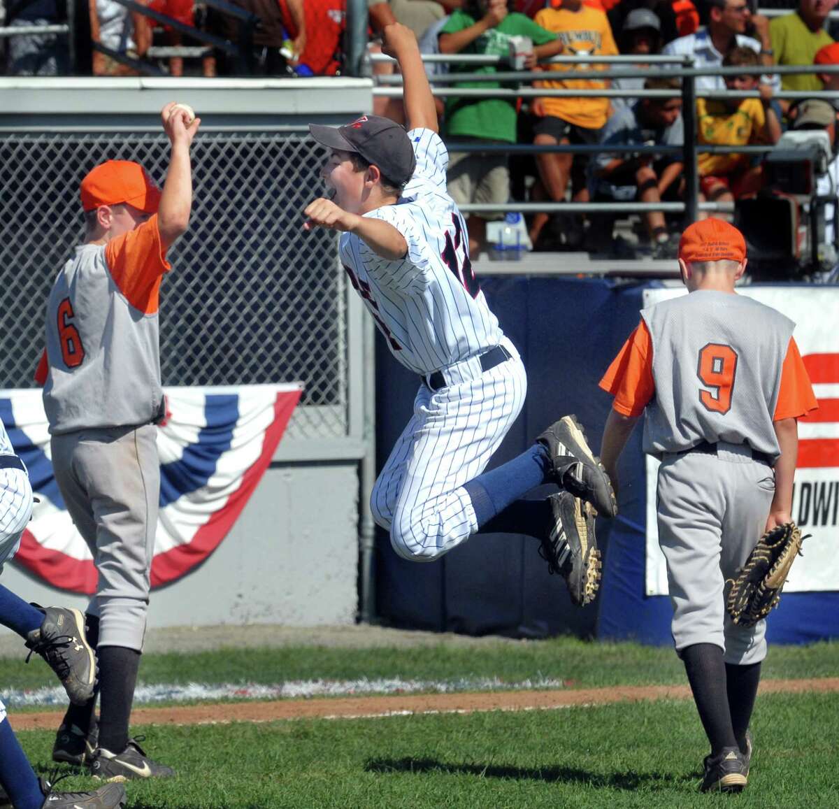 8/11/07 1Shelton LL ML0382A 2007 Eastern Regional LL Tournament, Bristol: Walpole's Samuel Falkson jumps for joy after Walpole beat Shelton for the spot at Williamsport. Shelton's closer Ryan Testani is at left, and Jacob Lennertz is at right return to the dugout. Photo by Mara Lavitt
