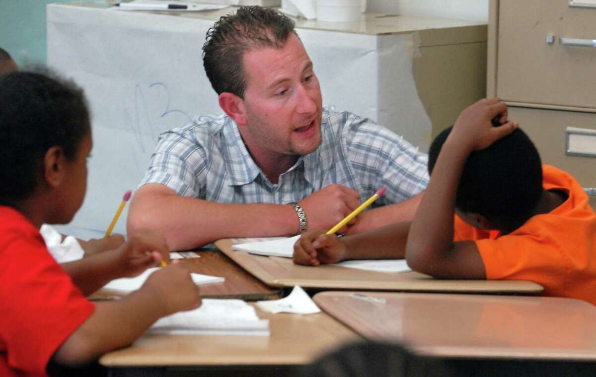 NE7/13/07 2School ML0373D Michael Satow works with New Haven fifth graders Ori Kellman left and Kenny Green on reading comprehension during the K-8 Summer Academy at East Rock Global Studies Magnet School in New Haven. Photo by Mara Lavitt