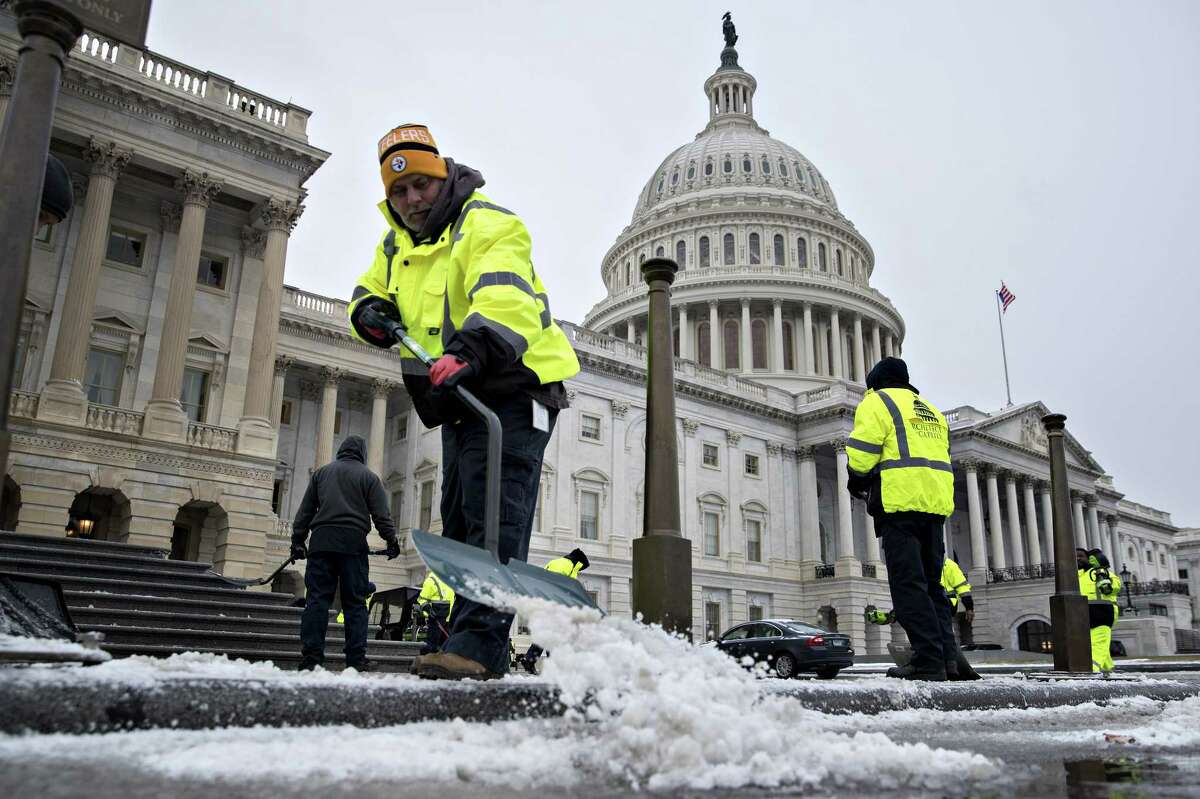 Workers shovel snow outside the U.S. Capitol in Washington on Jan. 4. (Bloomberg photo by Andrew Harrer)