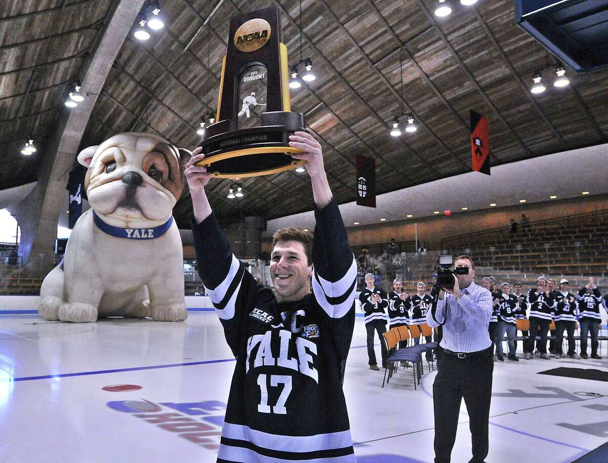 New Haven-- Yale's Andrew Miller carries the NCAA Hockey National Championship trophy into Ingalls Rink as they held a ceremony for the returning champions. Photo-Peter Casolino/Register pcasolino@newhavenregister.com