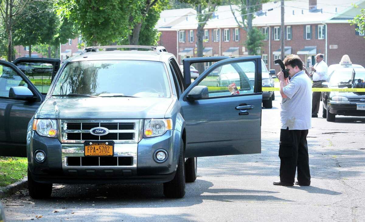 New Haven Detective Matthew Prinz photographs a Ford Escape on South Genesee St. in the McConaughy Terrace housing project in New Haven where the body of Timothy "T.J." Mathis was found on 9/3/2011. Photo by Arnold Gold/New Haven Register AG0423B