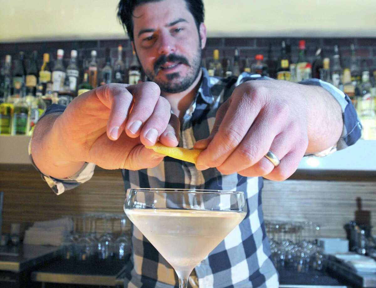 New Haven--John Ginnetti, owner of 116 Crown, finishes his classic martini with a twist. Photo by Brad Horrigan/New Haven Register-12.29.10.