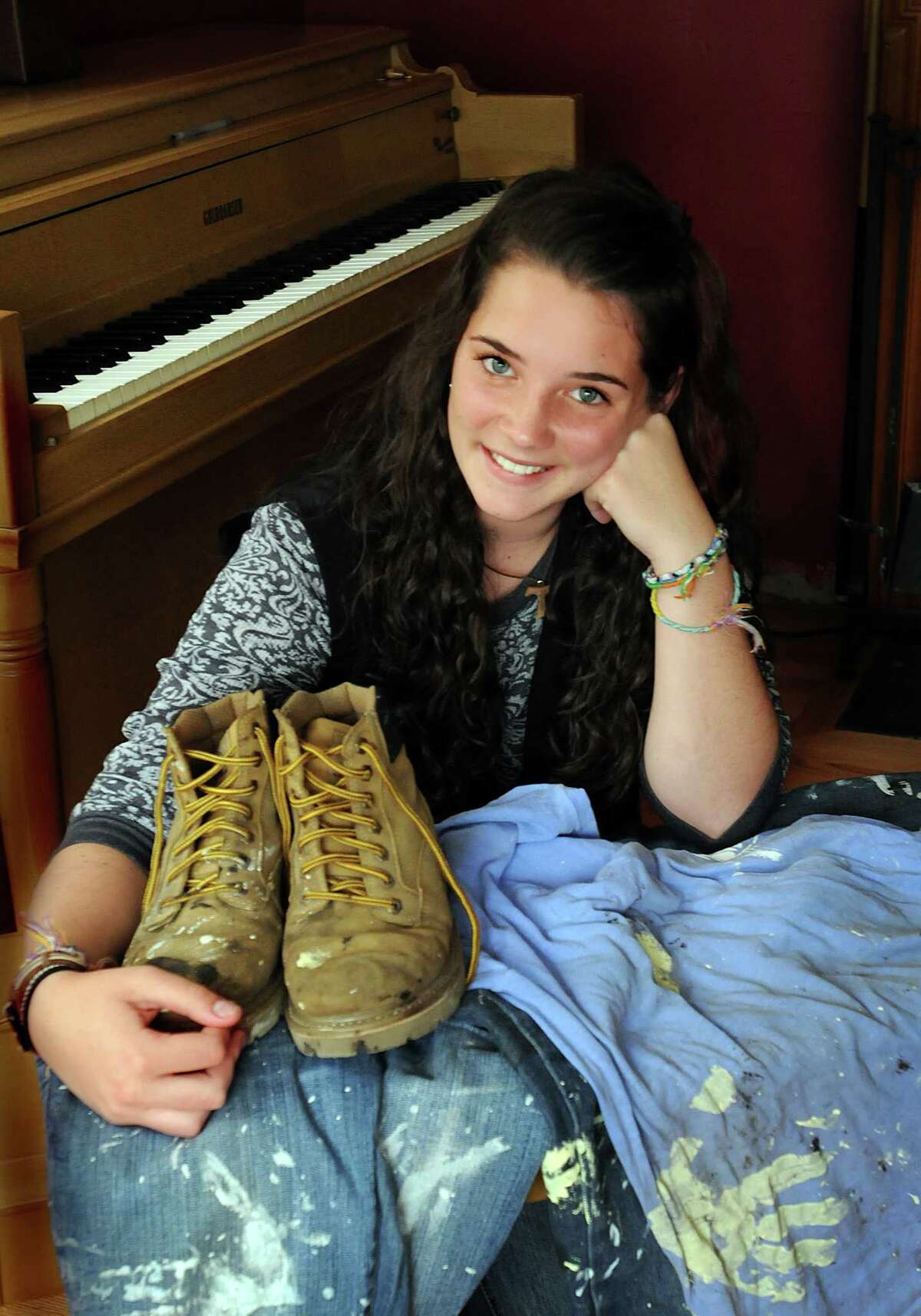 (ms082510)-Samantha Bowers, of Derby, with the clothes that she wore while volunteering in Kentucky. In the background is her piano. Melanie Stengel/Register