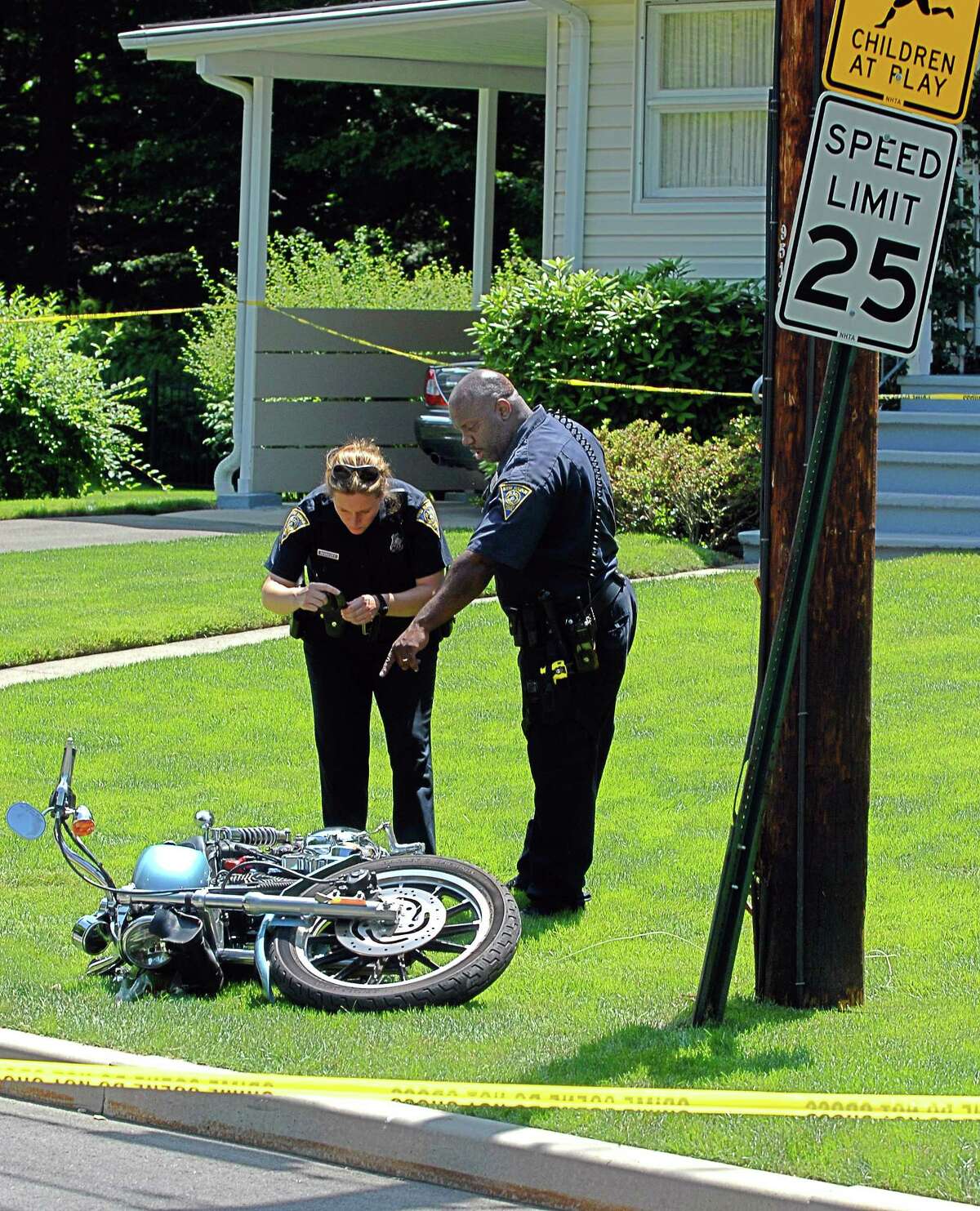 Cas100615 06/15/10 New Haven--New Haven Police Officers Kealyn Nivakoff and Lloyd Barrett investigate the scene of a motorcycle crash that killed a man along Curtis Drive (in front of #220). Photos -Peter Casolino/New Haven Register *