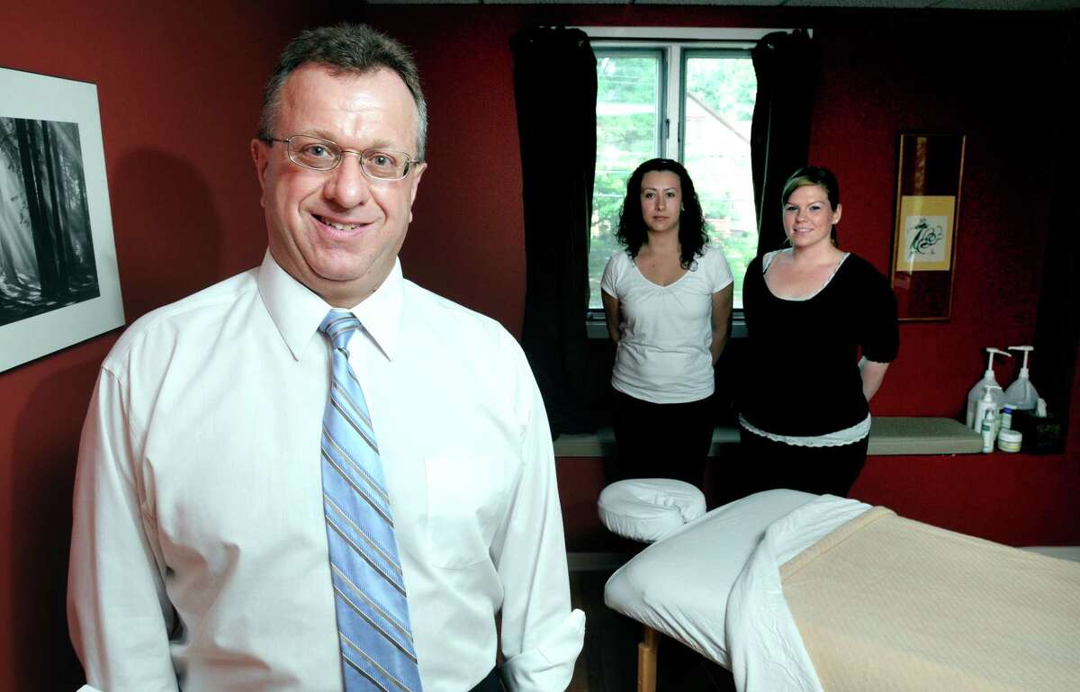 Dr. Robert Denes (left) is photographed on 8/11/2010 with licensed massage therapists Elcy Pareja (center) and Jessica Nieves-Diaz (right) in one of two massage rooms that he has added to his chiropractic business in Hamden. Photo by Arnold Gold AG0380F