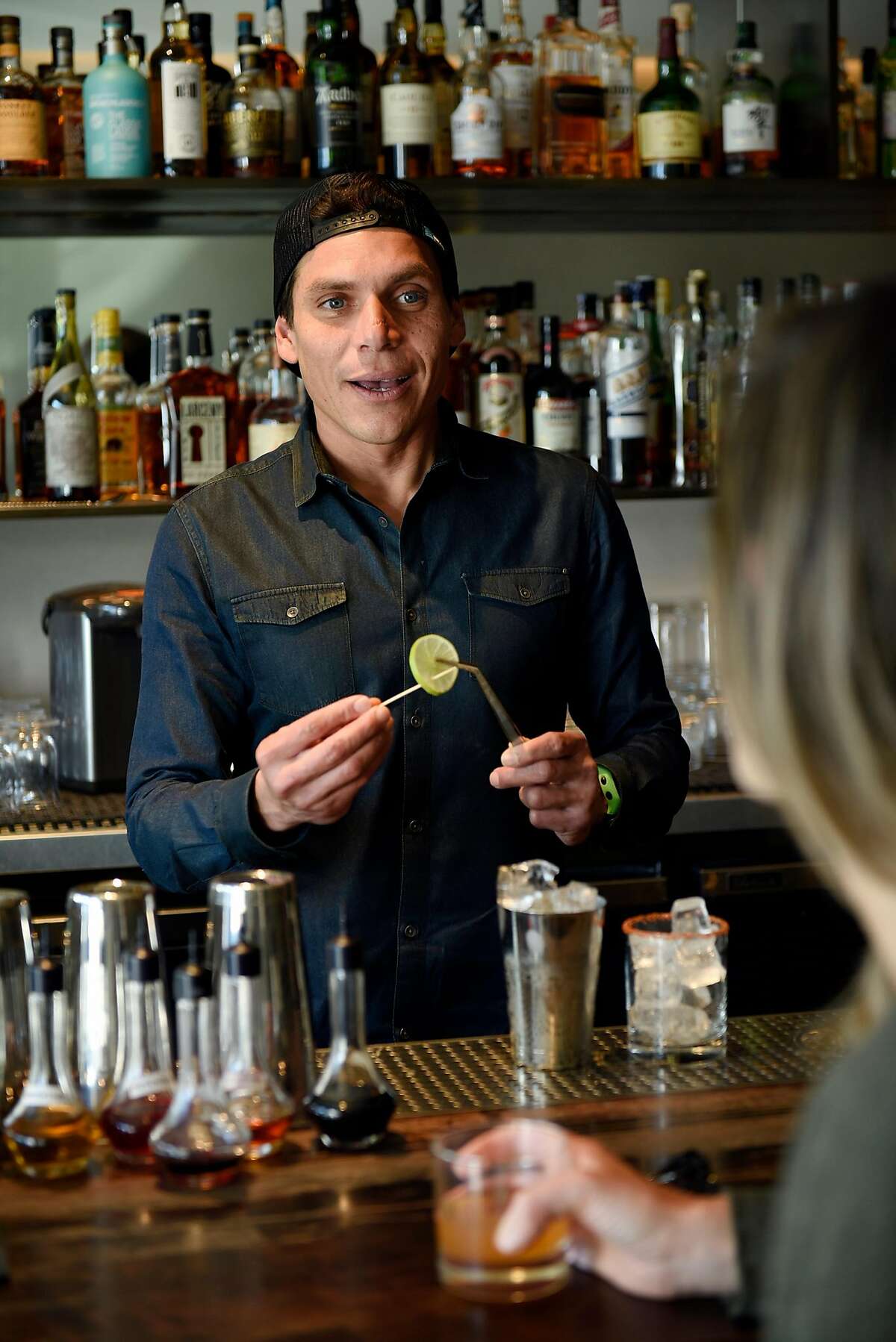 Head bartender Carlos Yturria talks with a customer while making a drink at the White Cap cocktail bar in San Francisco, Calif., on Saturday January 6, 2018.