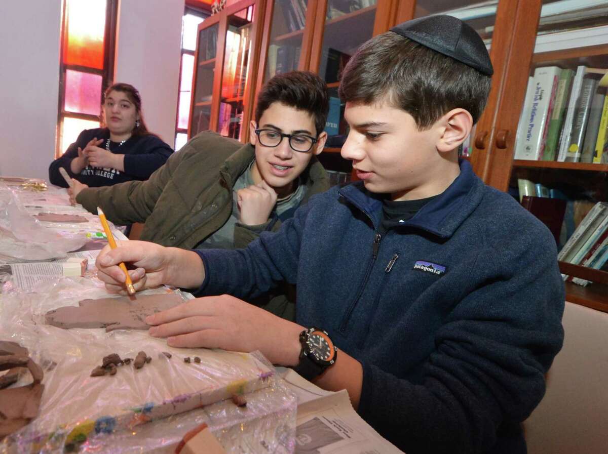 Ethan Gross and Jayson Hyman work on their clay hand prints at Beth Israel of Westport/Norwalk Chabad with the Circle of Friends on Sunday, Jan. 8, in Norwalk. Every month, high-schoolers volunteer to be buddies with children, teenagers and young adults with special needs through Circle of Friends, a program meant to provide social interaction.