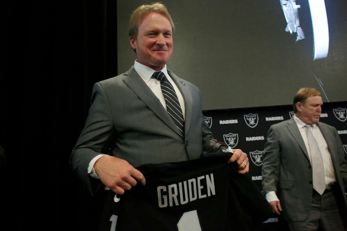 Jon Gruden (l to r), Oakland Raiders head coach, holds a Oakland Raiders jersey with his name as he stands next to owner Mark Davis after being introduced as the new head coach of the Oakland Raiders during a news conference at Raiders Headquarters on Tuesday, January 9, 2018 in Alameda, Calif.