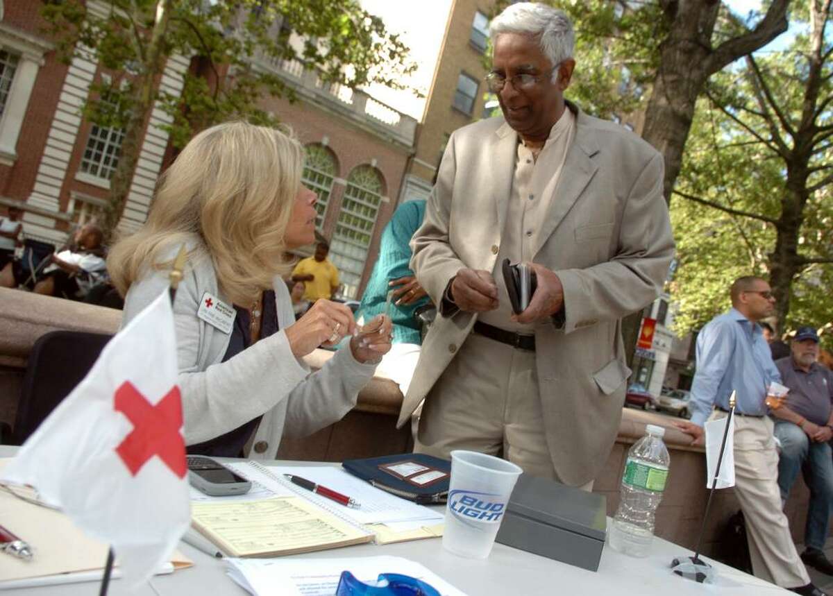 The Special O Band performed in the first Downtown Thursdays concert series on McLevy Green in downtown Bridgeport, Conn. on Thursday July 01, 2010. Here, Edward Samuel, of New Haven, makes a donation to the American Red Cross, which had a table set up at the concert to help the victims of the recent tornado. At the table is Lyn McCarthy.