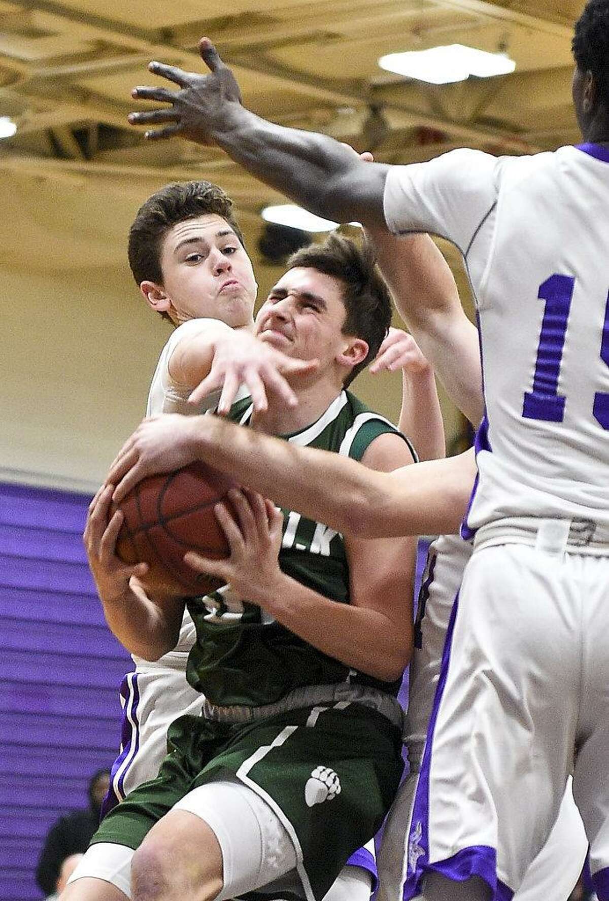 Westhill Jack Schlachtenhaufen (24) fouls Norwalk's Joe Benincaso (31) on his drive to the basket between Schlachtenhaufen and Westhill Wyklend Turene (15), at right, during a FCIAC boys basketball game at Westhill High School in Stamford, Conn. on Tuesday, Jan. 9, 2018.
