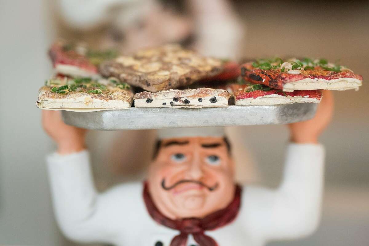 A statue holds a tray of focaccia, hand sculpted by Danny Soracco, in a window display at Liguria Bakery on Friday, Jan. 5, 2018, in San Francisco.