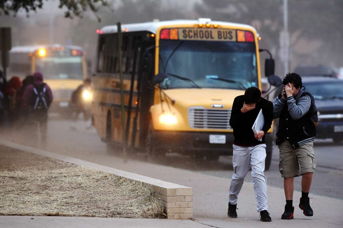 Lee High School students cover their faces as high winds kick up dirt and debris Jan. 10, 2018 near the school. James Durbin/Reporter-Telegram