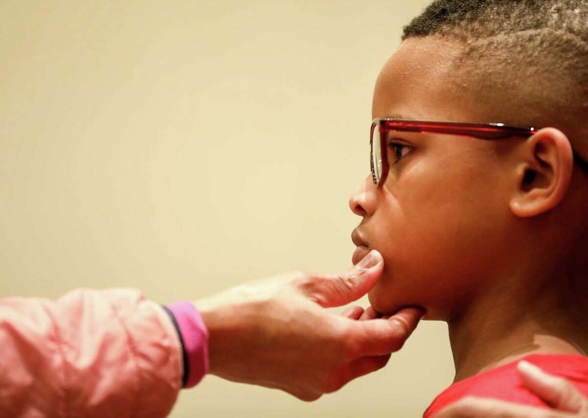 Chaise Perry, 8, gets his new frames checked out by Denetrice Coleman, O.D., during an event to get eye glasses to low-income students from the Houston area, Wednesday, Jan. 10, 2018, in Cypress.