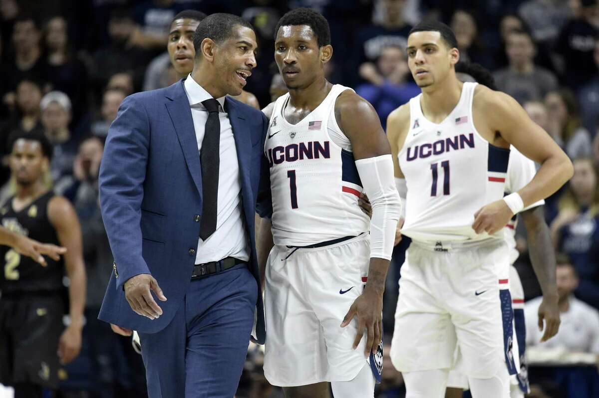 Connecticut head coach Kevin Ollie talks with guard Christian Vital (1) after he was flagrantly fouled by UCF's Dayon Griffin during the first half at Gampel Pavilion in Storrs, Conn., on Wednesday, Jan. 10, 2018.