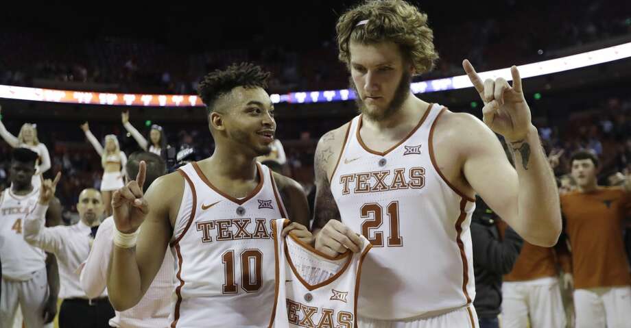 Texas guard Eric Davis Jr. (10) and forward Dylan Osetkowski (21) hold the jersey of teammate Andrew Jones (1) during the school song following an NCAA college basketball game against TCU, Wednesday, Jan. 10, 2018, in Austin, Texas. The team debuted the "AJ1" logo on their jerseys to honor guard Jones, who has been diagnosed with leukemia. Texas won in double overtime, 99-98. (AP Photo/Eric Gay) Photo: Eric Gay/Associated Press
