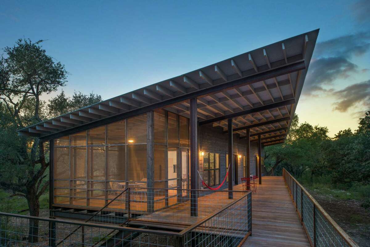 Winner of an American Institute of Architects 2017 design award, the cabin designed by Candid Rogers Architect is a family retreat on the Sabinal River near the small Hill Country town of Utopia. The cabin is powered via a solar-panel system and propane. It has two bedrooms, two full baths (plus an outdoor bath tub), a kitchen and living room, a screened porch and a long, wide porch facing the river. Because it is in the flood plain, the cabin was built on a steel I-beam structure.