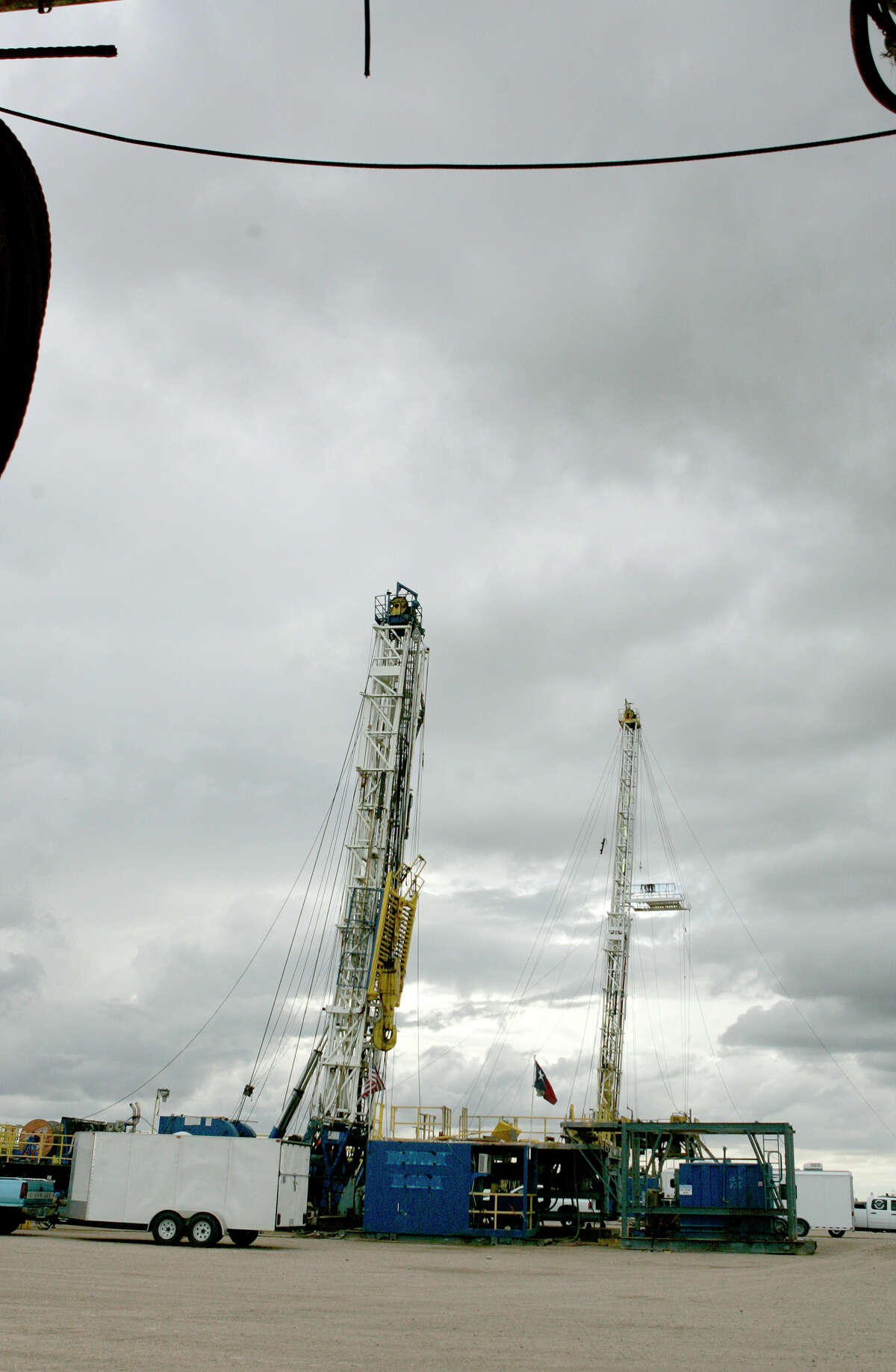 A pair of drilling rigs with will soon be deployed into the field sit in the Desta Drilling yard.