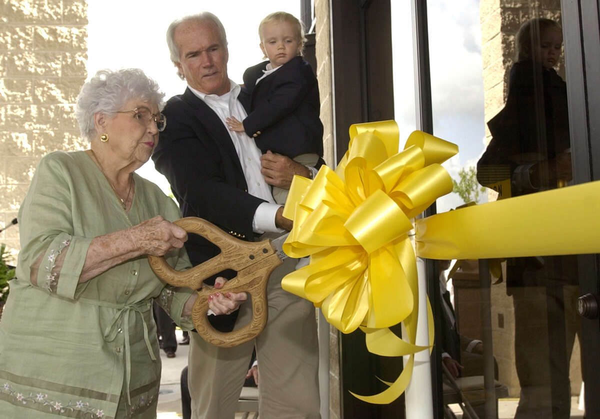 FOR THIS WEEK--Vera Brummett May, left, cuts the ceremonial ribbon to open the May Community Center with County Commissioner Jerry Eversole and his grandson, Hayden Stone Eversole, Thursday, July 10, 2003, in Huffman, Texas. (Photo by Brett Coomer/Special to the Chronicle) HOUCHRON CAPTION (07/17/2003): Vera Brummett May, for whom the May Center in Huffman is named, performs the official ribbon cutting for the renovated center. Harris County Commissioner Jerry Eversole, holding grandson Hayden Stone Eversole, positions the ribbon for the symbolic shears.