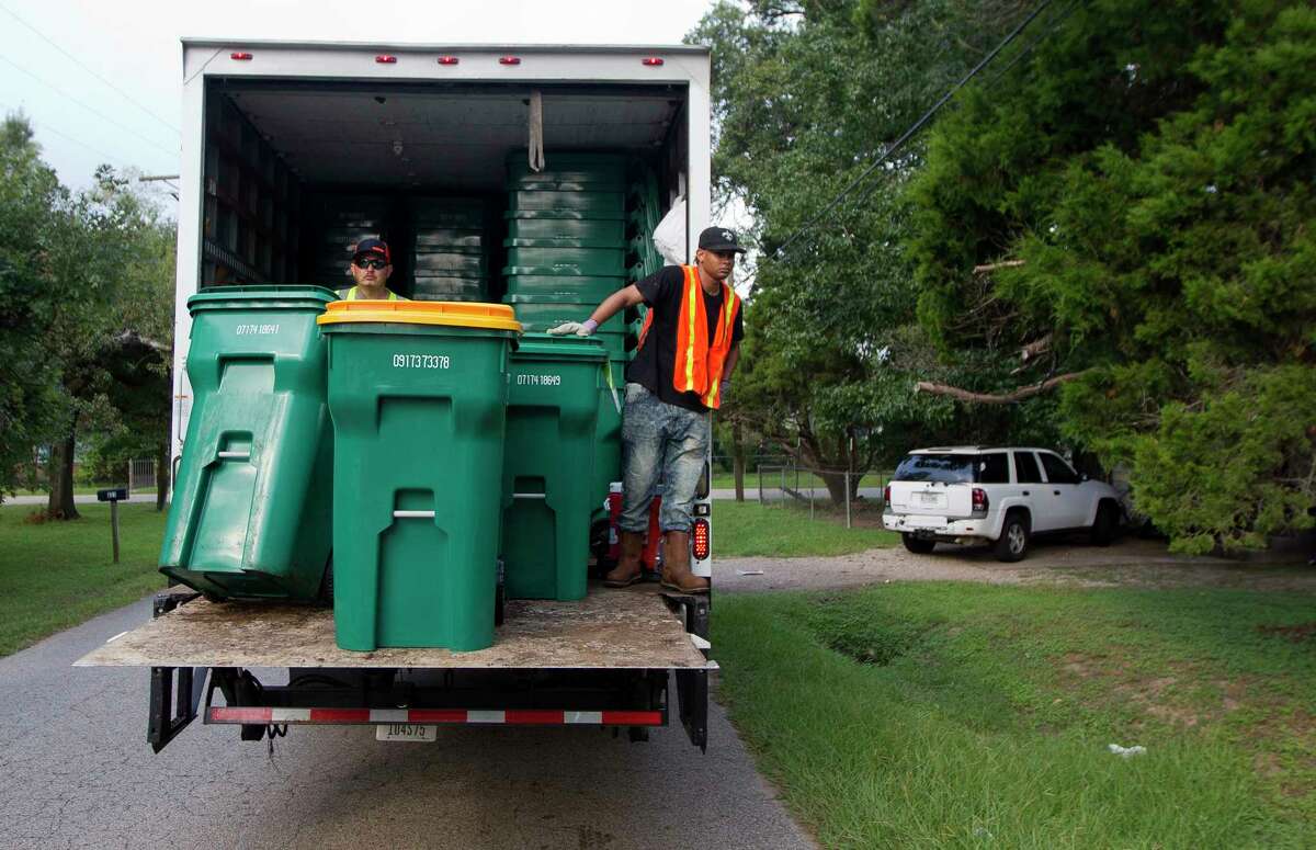Chris Mcglory rides a truck as he helps unload new Waste Management issued recycling trash and recycle bins on Mill Avenue, Thursday, Sept. 21, 2017, in Conroe. The Conroe City Council voted in April to not renew the city's contract with long-time provider Republic Services Inc.