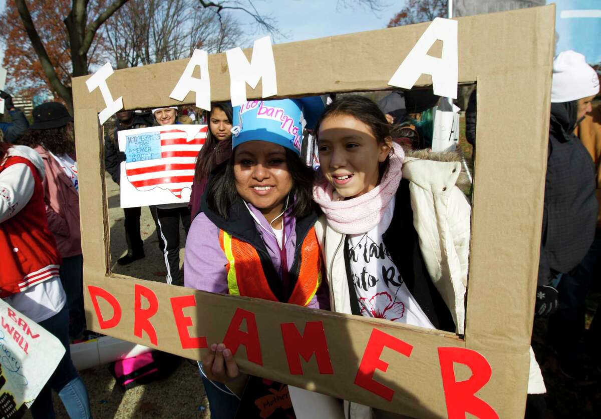 Demonstrators Karina Velasco, left, and Gabi Sanchez hold a sign during an immigration rally in support of the Deferred Action for Childhood Arrivals (DACA), and Temporary Protected Status (TPS), programs, on Capitol Hill in Washington, Wednesday, Dec. 6, 2017. ( AP Photo/Jose Luis Magana)
