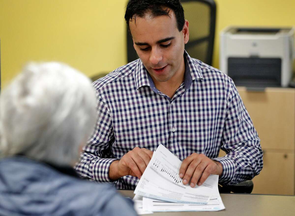 Senior Analyst Omar Masry helps Marcy Lipton with her paperwork for hosting guests in her home at the Office of Short Term Rentals in San Francisco, Calif., on Wednesday, January 10, 2018. San Francisco residents who wish to host guests host guests through Airbnb, VRBO or other homesharing services must register with SF by Jan. 16 or they will be penalized by the city.