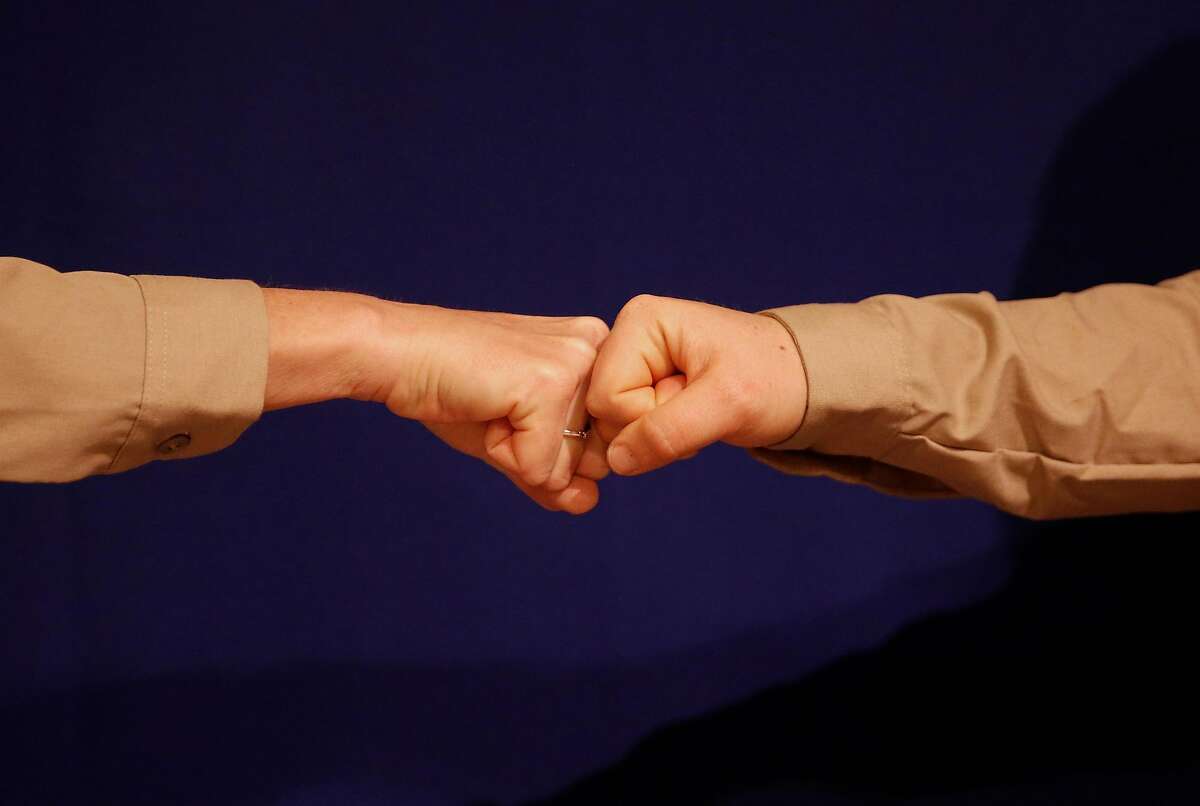 Alison Pebworth, left, and Hannah Ireland demonstrate different types of handshakes before opening the Unofficial Department of Handshakes on Friday, Jan. 12, 2018 at City Hall in San Francisco, Calif.