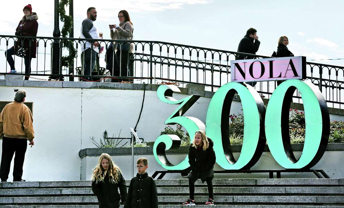 Tourists and locals hang out near a "NOLA 300" sign at Washington Artillery Park as New Orleans celebrates it's Tricentennial, the same year that San Antonio does, on Friday, Jan. 5, 2018.