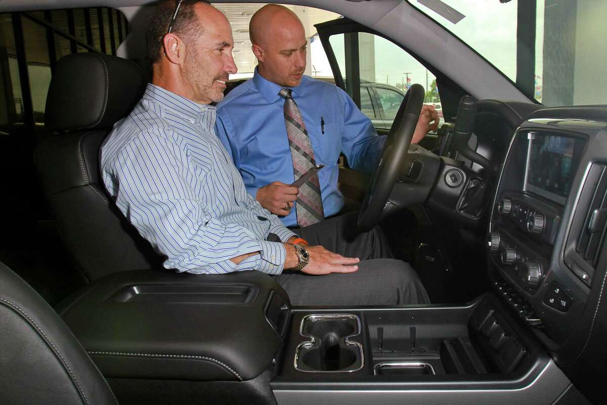 Customer Randy Parker, left, and Awni Kawar, of Munday Chevrolet at 17800 North Fwy., look at a 2015 Silverado 1500 Z71 4WD LTZ Crew Cab truck. Munday Chevrolet was purchased last year by Group 1 Automotive. (For the Chronicle/Gary Fountain, May 28, 2015)