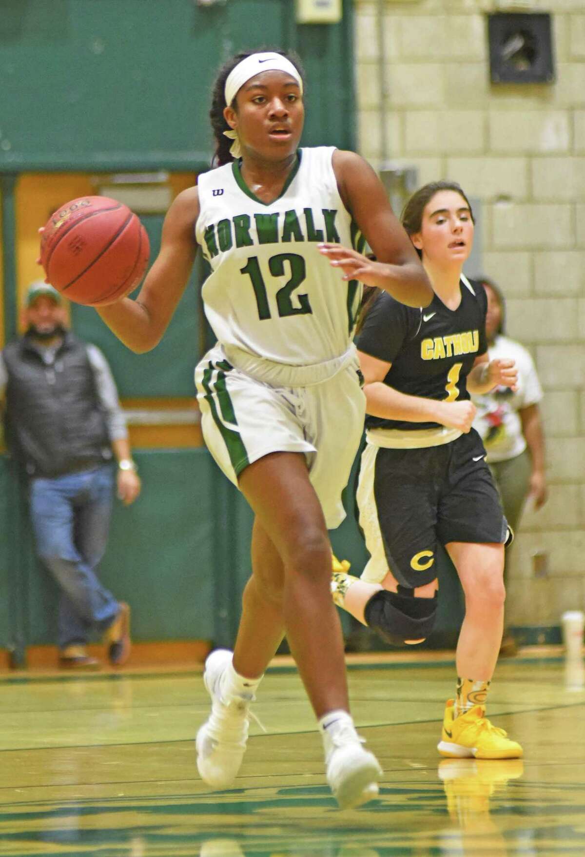 Norwalk’s Sanaa Boyd, left, pushes the ball up the floor in front of Trinity Catholic’s Emma Gainer during Friday’s FCIAC girls basketball game in Norwalk.