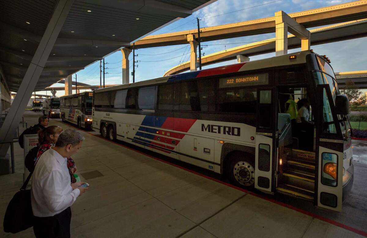 Morning commuters wait in line to board a Metro bus at the Grand Parkway Park and Ride on Dec. 20.