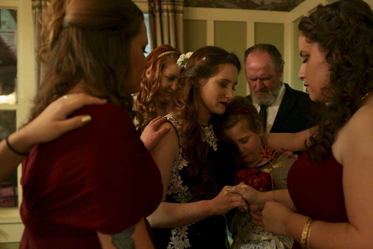 Amanda Pomeroy, 9, leans on her aunt, Morgan Harris, as Morgan is surrounded in prayer by her bridesmaids and her father, Darrell Harris, before her wedding at Spinelli's in Comfort on Thursday, Jan. 11, 2018.