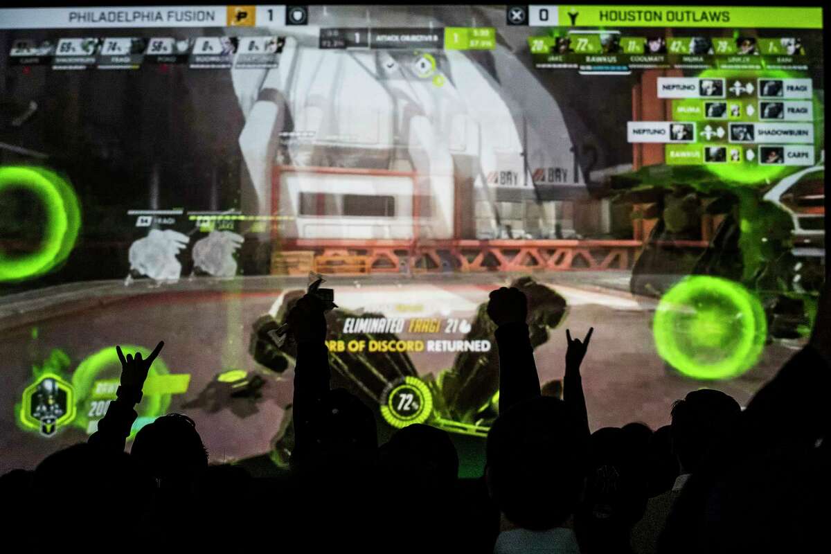 Houston Outlaws fans cheer during a watch party for the esports team Thursday night at a warehouse that will be converted into a $70 million 120,000-square-foot co-working space.