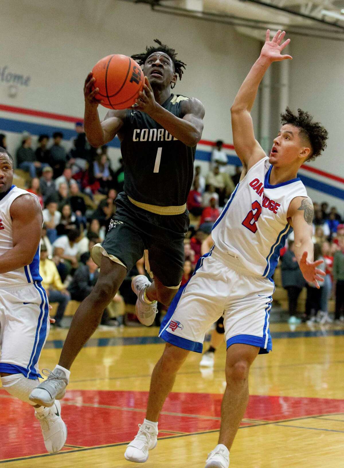 Conroe guard Jay Lewis (1) shoots under pressure by Oak Ridge guard Cristian Calix (2) during the fourth quarter of a District 12-6A high school boys basketball game at Oak Ridge High School, Friday, Jan. 12, 2018.