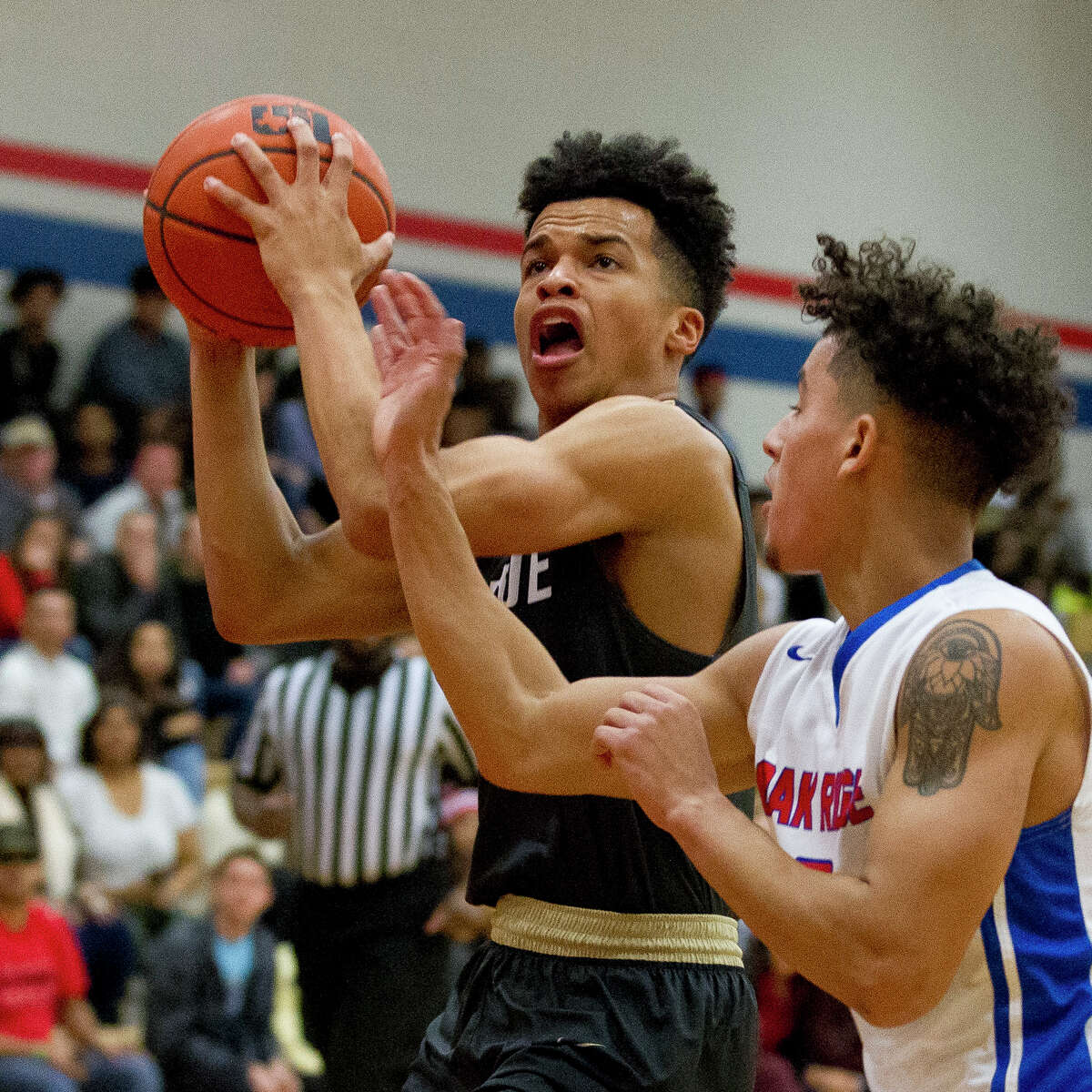 Conroe guard Antonio Evans (5) goes up for a shot against Oak Ridge guard Cristian Calix (2) during the third quarter of a District 12-6A high school boys basketball game at Oak Ridge High School, Friday, Jan. 12, 2018.